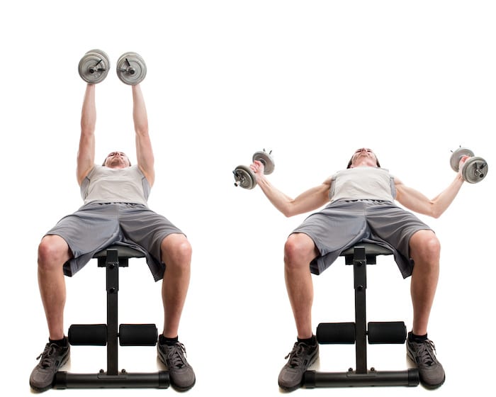 Dumbbell fly exercise. Studio shot over white.